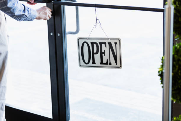 istock Man opening a store, unlocking the door 930530890