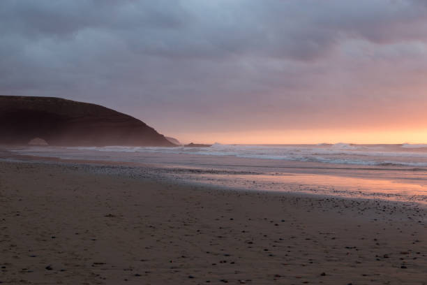 istock Stone arch by the ocean at beautiful red orange glowing sunset 930531112