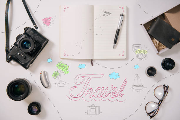 Accessories for travel. Top view of notebook and photo camera lying on the table