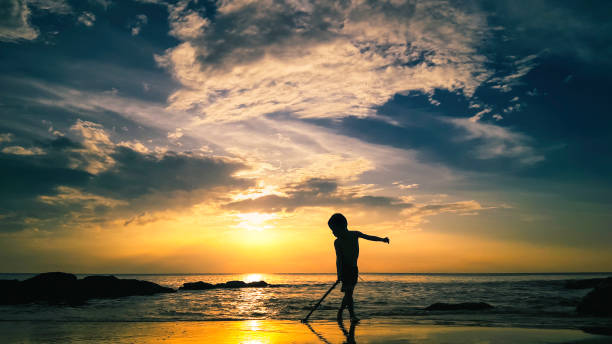 Jeune garçon glisser le bâton au lever du soleil - Photo