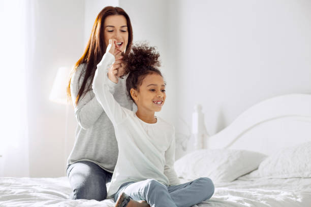 istock Smiling mother making a hairdo for her daughter 930546620
