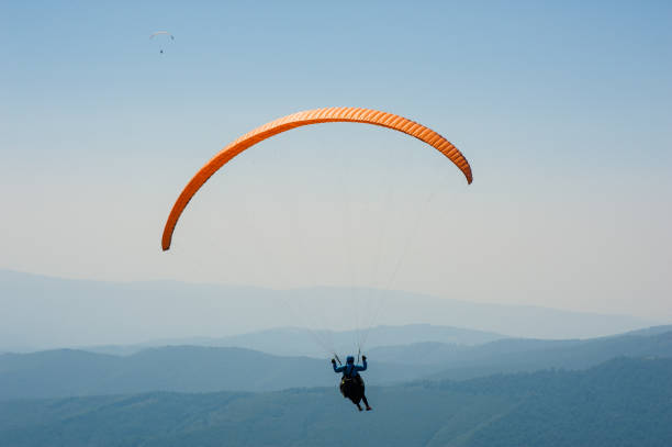 istock Paraglider flies over a mountain valley on a sunny summer day. 930546990