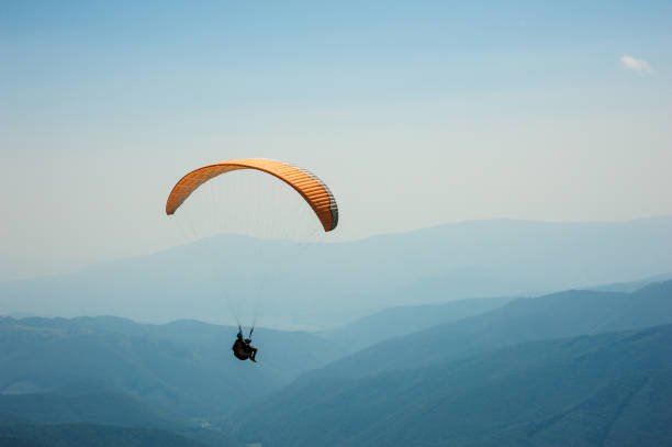 istock Paraglider flies over a mountain valley on a sunny summer day. 930547028