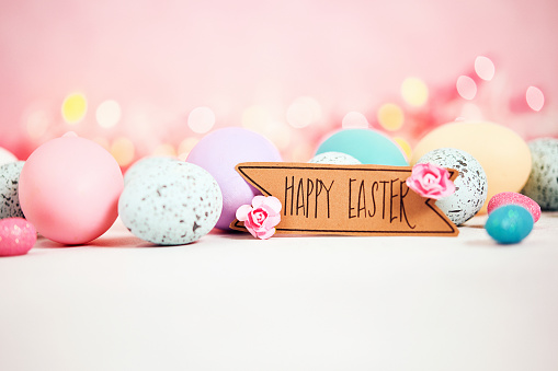 Pastel pink background with message and pastel eggs for Easter