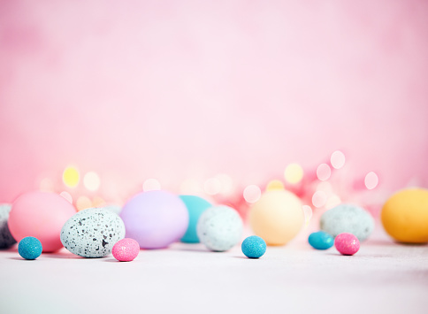 Pastel pink background with pastel eggs for Easter