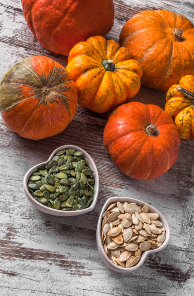 istock Pumpkins and seeds overhead in ceramic jars on wooden table 930555204