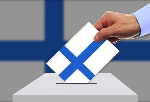 Man voting on elections in Finland front of flag