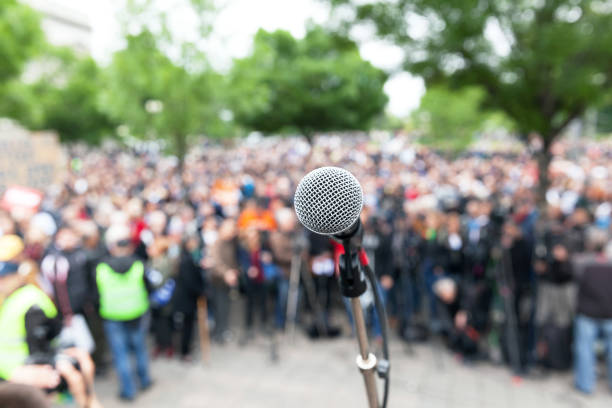 istock Political protest. Demonstration. Microphone in focus against blurred crowd. 930571848
