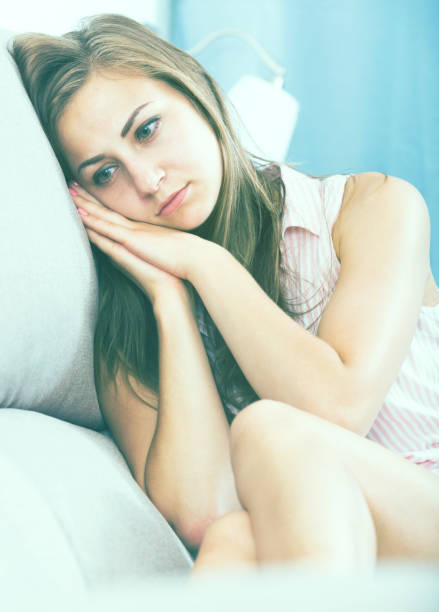 istock Disappointed girl sitting on sofa 930574186