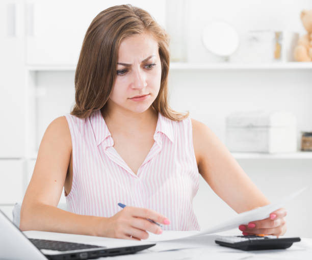 istock Young woman looking worriedly at bills 930574242