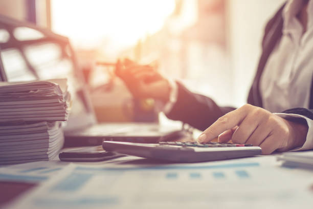 business woman using calculator and writing make note with calculate. woman working at office with laptop and documents on his desk - planning manager paperwork business imagens e fotografias de stock