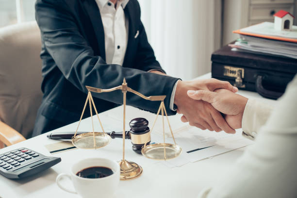 Businessman shaking hands to seal a deal with his partner lawyers or attorneys discussing a contract agreement stock photo