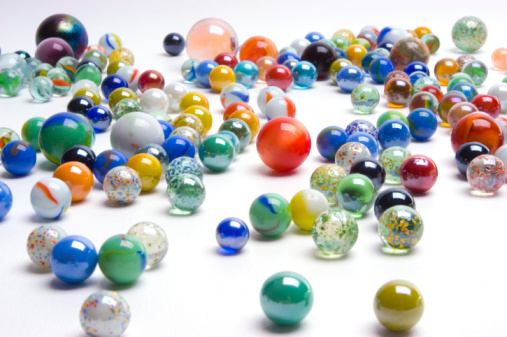 A bunch of marbles scattered on a white background.