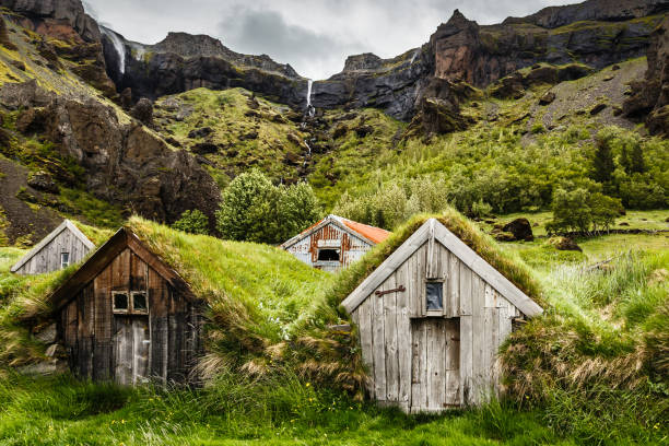 islandzkie domy murawy i skalisty kanion z wodospadem w tle w pobliżu kalfafell vilage, południowa islandia - turf house zdjęcia i obrazy z banku zdjęć