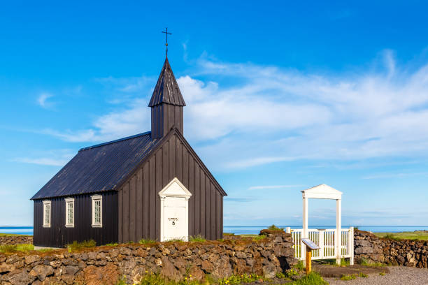istock Budakirkja black painted Lutheran parish erected in 1847 with blue sky and clouds in the background, Snaefellsnes Peninsula, West Iceland 930592176