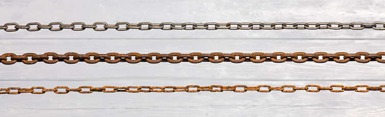 old iron chains on a white wooden background
