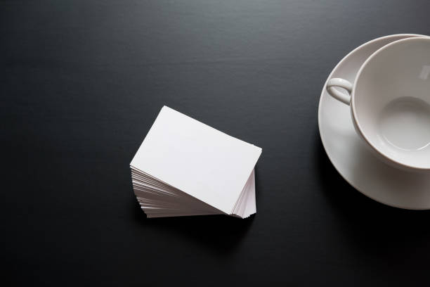 istock white business cards with space for text are stacked next to an empty white cup for drinks 930607608