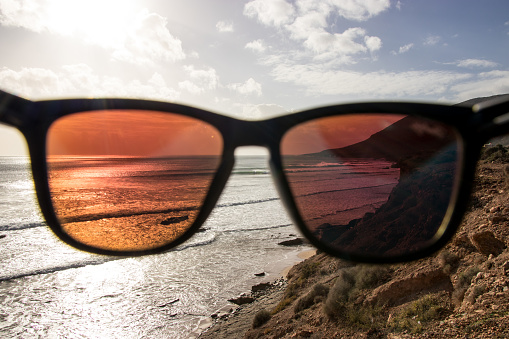 Looking through sunglasses at beach and waves - point of view