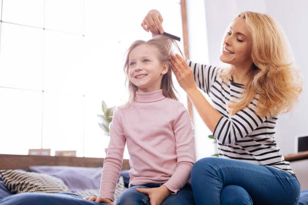 istock Cheerful mother combing her daughters hair 930622480