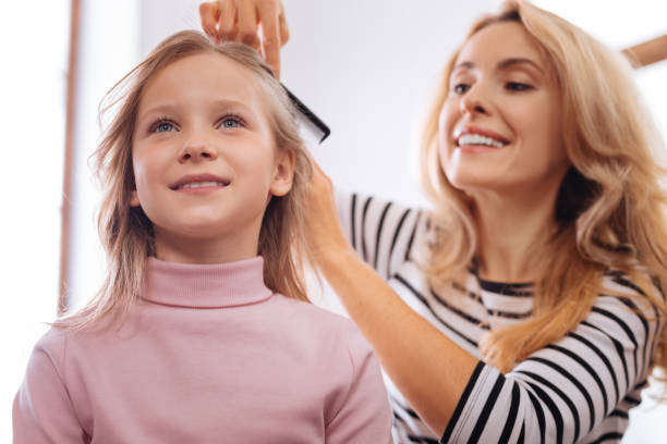 istock Loving mother combing her daughters hair 930622488