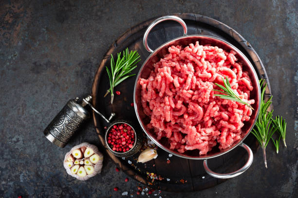 istock Cooking mince. Raw ground veal meat with ingredients for cooking on black kitchen table. Fresh minced meat, top view 930622542