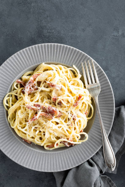 istock Carbonara pasta, spaghetti with pancetta, egg, hard parmesan cheese and cream sauce. Traditional italian cuisine. Pasta alla carbonara 930626014
