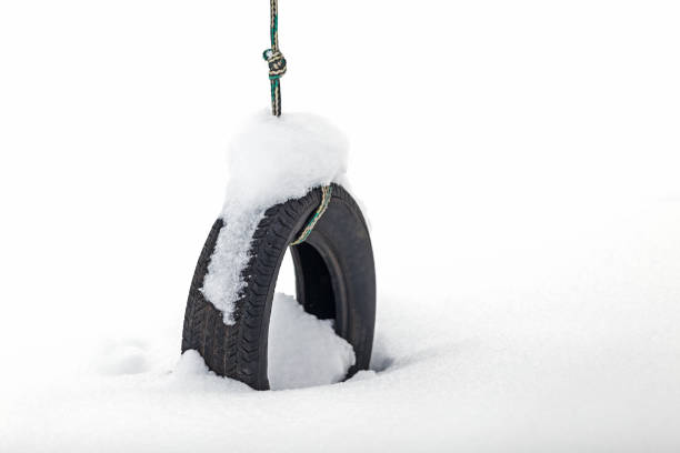 A tire swing in deep powder snow after a winter snowstorm.