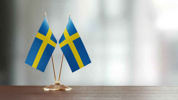istock Swedish  Flag Pair On A Desk Over Defocused Background 930657802