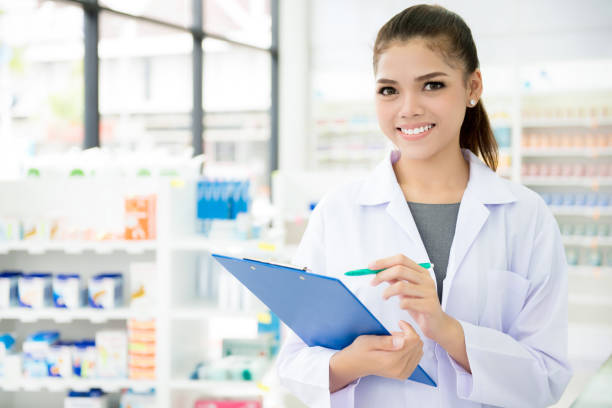 Asian female pharmacist working in chemist shop or pharmacy stock photo