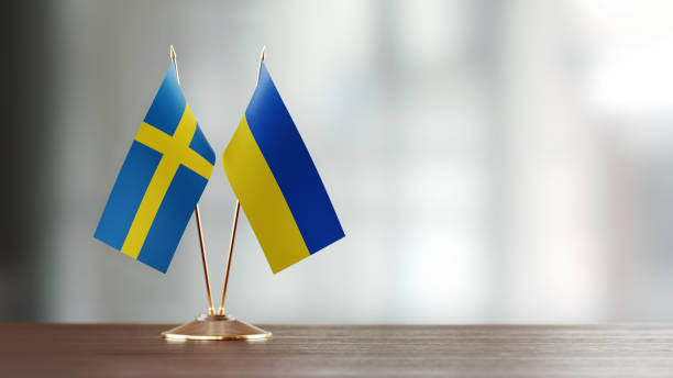 istock Swedish And Ukrainian Flag Pair On A Desk Over Defocused Background 930659950