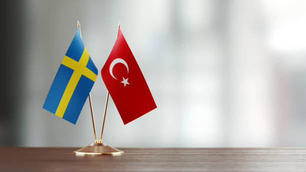 istock Swedish And Turkish Flag Pair On A Desk Over Defocused Background 930661390