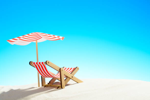 istock A chaise longue under an umbrella on the sandy beach, sky with copy space 930666832