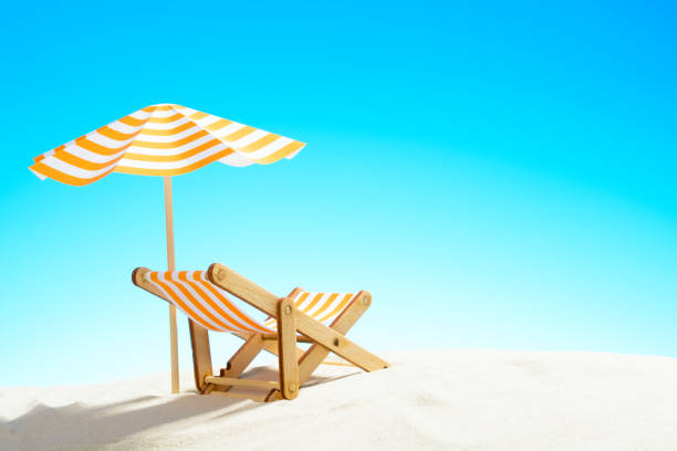 istock A chaise longue under an umbrella on the sandy beach, sky with copy space 930666838