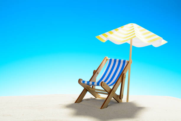 istock A chaise longue under an umbrella on the sandy beach, sky with copy space 930666846