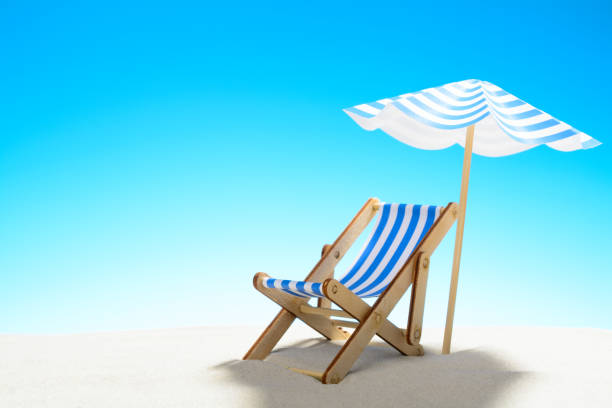 istock A chaise longue under an umbrella on the sandy beach, sky with copy space 930666848