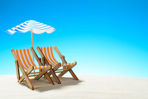 istock Two chaise longue under an umbrella on the sandy beach, sky with copy space 930666850