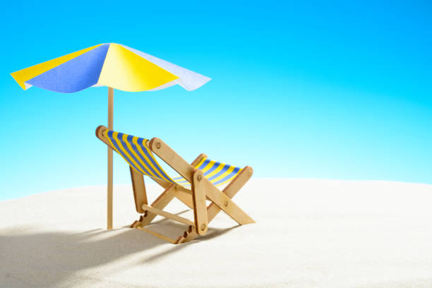 istock A chaise longue under an umbrella on the sandy beach, sky with copy space 930666856