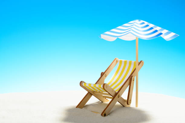 istock A chaise longue under an umbrella on the sandy beach, sky with copy space 930666860