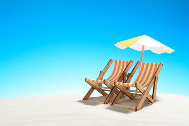 istock Two chaise longue under an umbrella on the sandy beach, sky with copy space 930666866