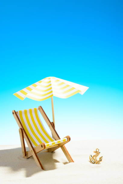istock A chaise longue under an umbrella on the sandy beach, sky with copy space 930666868