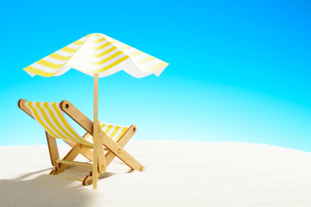 istock A chaise longue under an umbrella on the sandy beach, sky with copy space 930666870