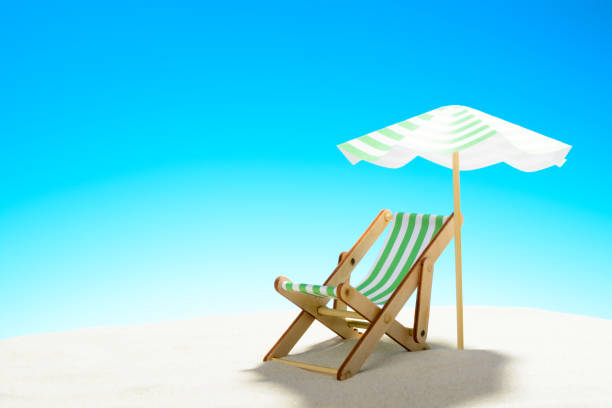 istock A chaise longue under an umbrella on the sandy beach, sky with copy space 930666872
