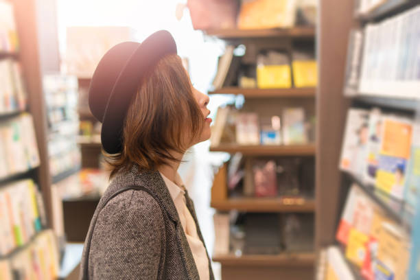 若い女性の店で本を探して - smart casual side view one person success ストックフォトと画像