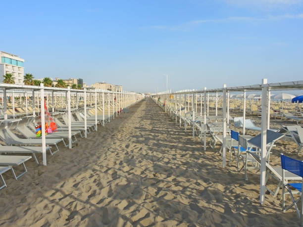 istock Beach umbrellas, gazebos and sun beds at Italian sandy beaches. Adriatic coast. Emilia Romagna region 930700608