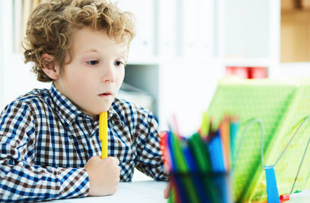 istock Portrait of pupil in school class taking notes during writing le 930701300