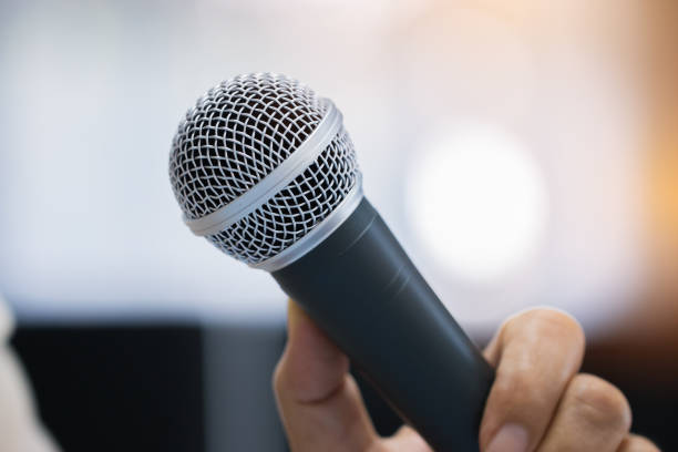 istock Seminar Speaking Conference Concept : Microphone of speech in seminar room or speaking conference hall light bokeh background. Speaker Business tedtalk is vocalized form of communication humans. 930705772