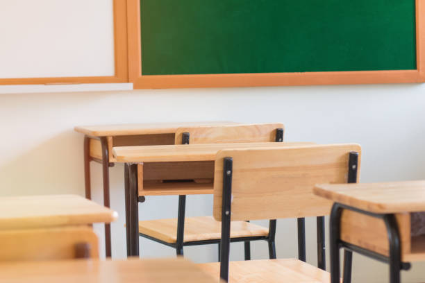 istock Chair in empty classroom, lecture armchairs with chalkboard in school, or college 930711806