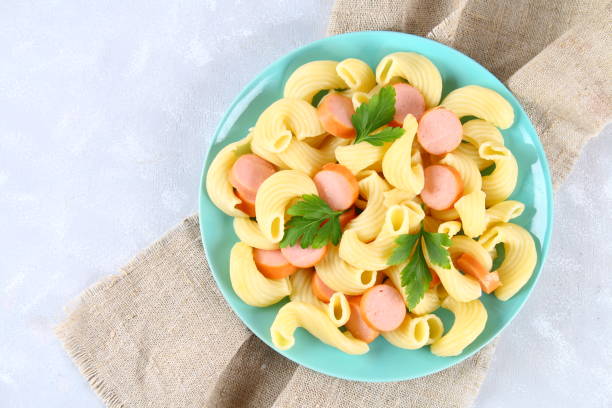 istock Pasta Cavatappi or Cellentani with sausages on a gray table. 930715900