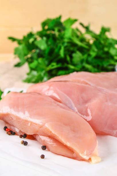 istock raw chicken fillets on wooden cutting board. 930716028