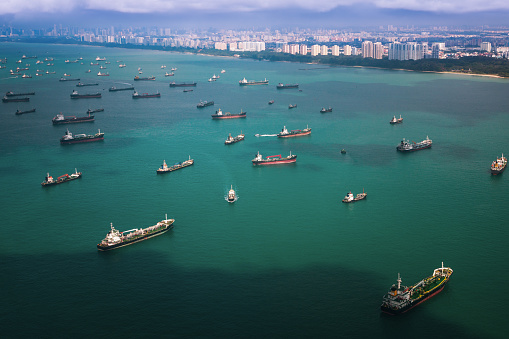 Top view from airplane of Singapore harbor with transportation boat and container ship